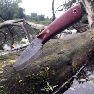 A knife is laying on the ground near some water.