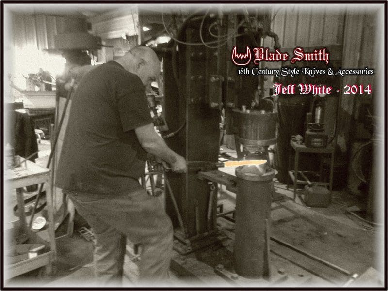 A man working with metal in an old fashioned way.