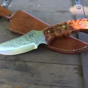 A knife laying on top of a wooden table.