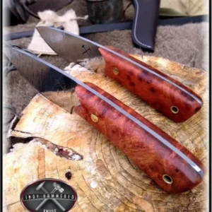 A pair of knives on top of a wooden board.