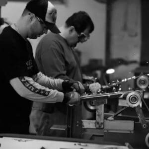 Two men working on a machine in a shop.