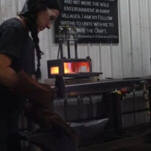 A person in black shirt working on metal object.