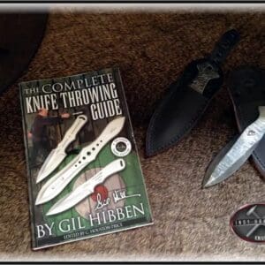 A book about knives and some scissors on the floor