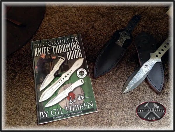 A book about knives and some scissors on the floor