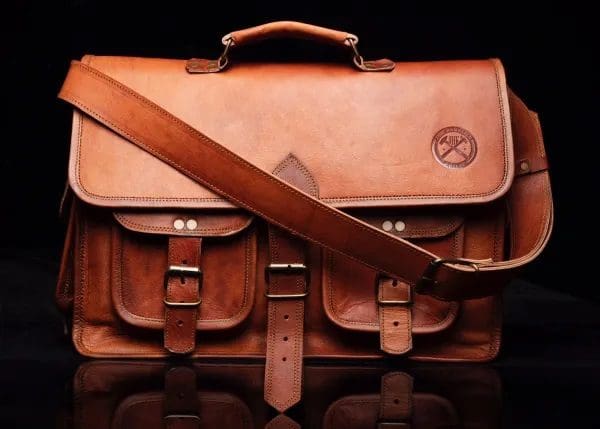 A brown leather bag with a strap on it.