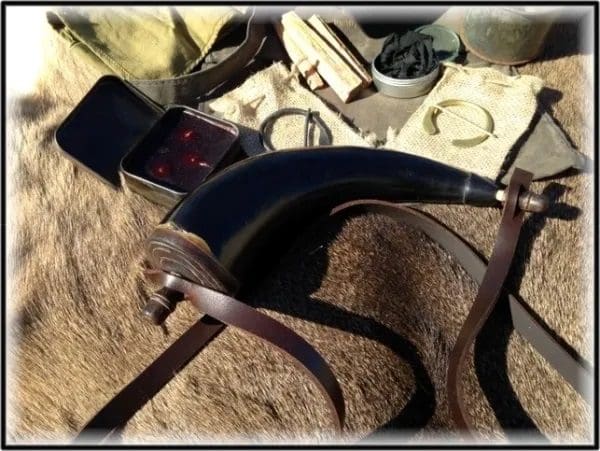 A horse harness and some other items on the ground.