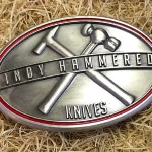 A belt buckle with the words " cindy hammered knives ".