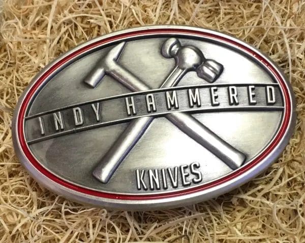 A belt buckle with the words " cindy hammered knives ".