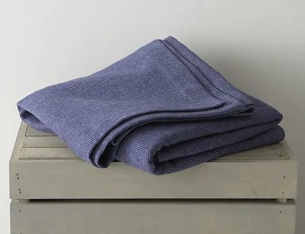 A folded blanket on top of a wooden table.