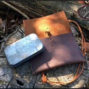 A bag and tin sitting on the ground.