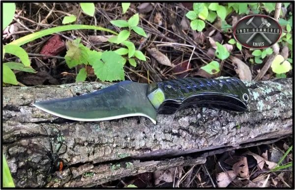 A knife laying on the ground in the woods.