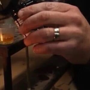 A person wearing a gold ring with their hands