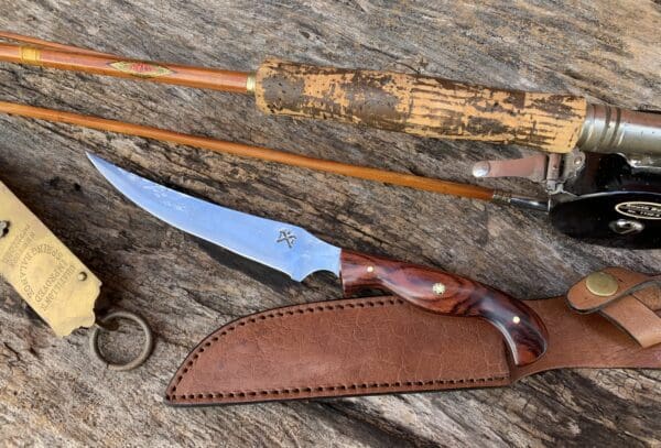 A knife and some sticks on top of a wooden table.