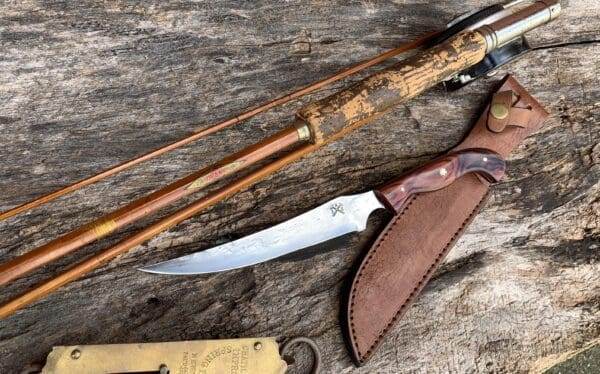 A knife and some wooden sticks on top of a table.